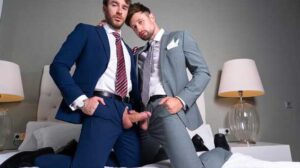 Sitting on the corner of the bed, fully suited, horned up Charlie Cherry is jerking off his monster cock through the fly of his pants. He wipes the precum off his cock with his striped tie and keeps jerking ever so gently.